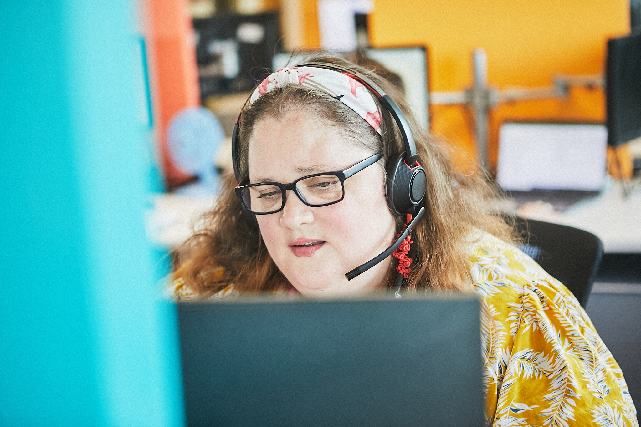 Gene, a Memory Support Worker, wearing a headband, glasses and headset, talking to a patient