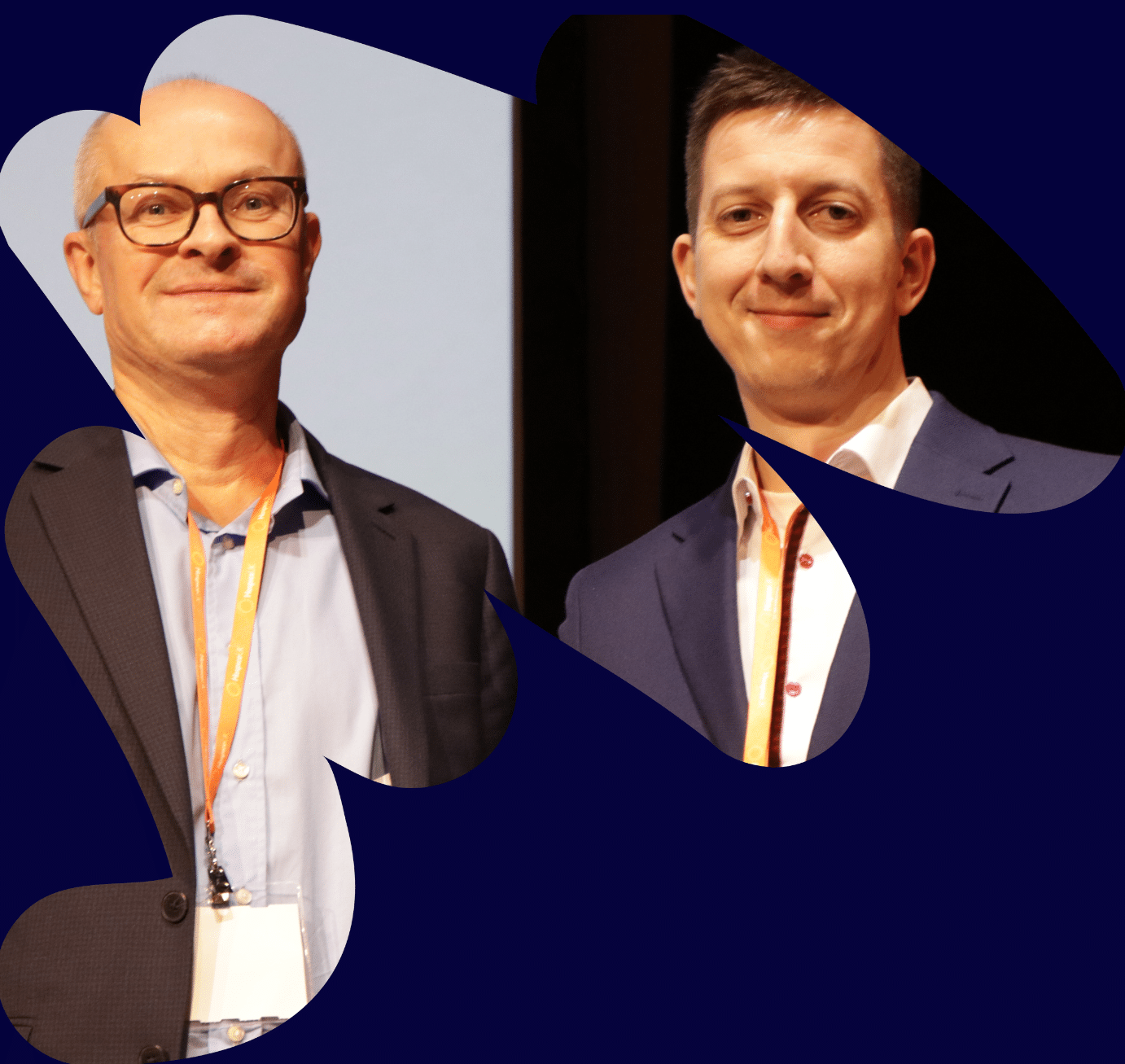 Matthew Riley - a man wearing glasses, a grey suit jacket and blue jacket is stood smiling. Next to him stand a man with dark hair and a blue suit holding the Hospice UK Digital Champion Award